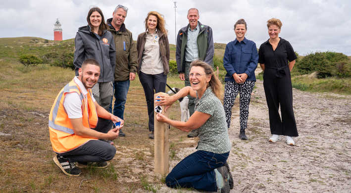 Samenwerkende partners Wandelnetwerk Texel plaatsen eerste routepaal.